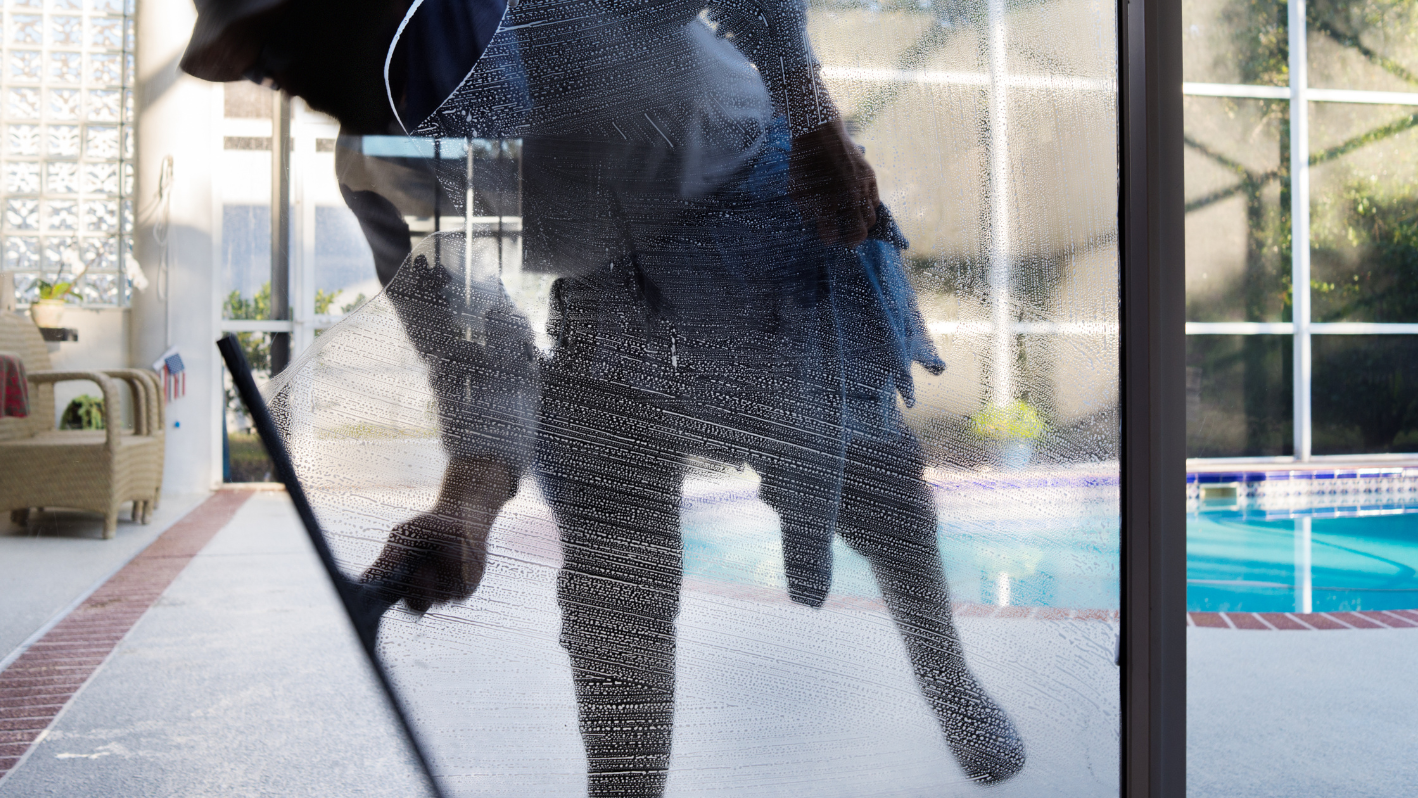 A man standing in front of a window holding an umbrella