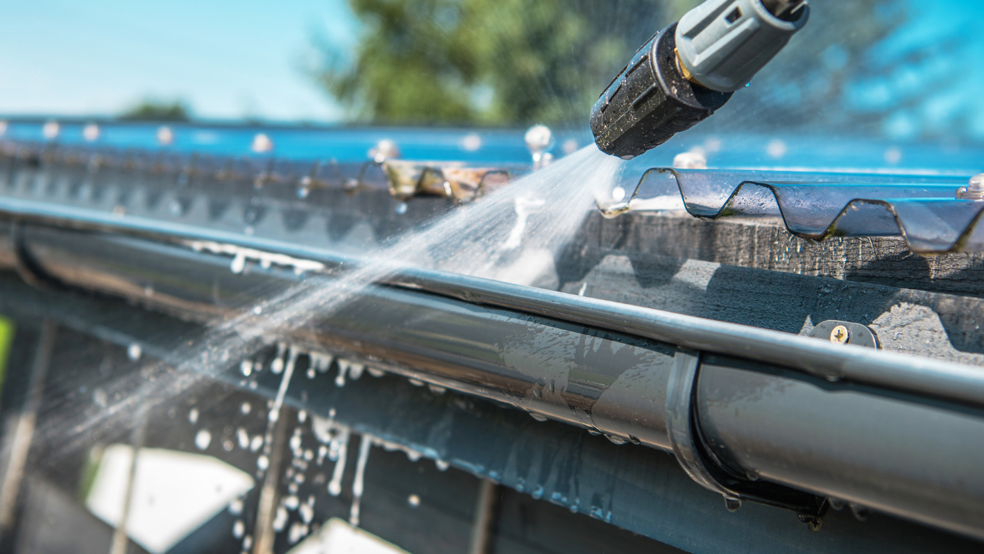 A close up of a gutter hose spraying water on a gutter gutter